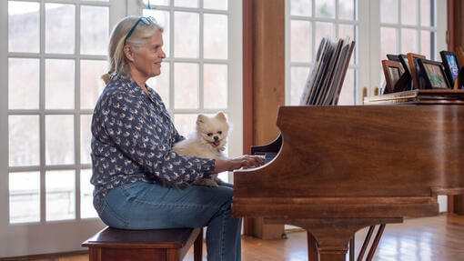 Koira kuuntelee omistajan soittavan pianoa